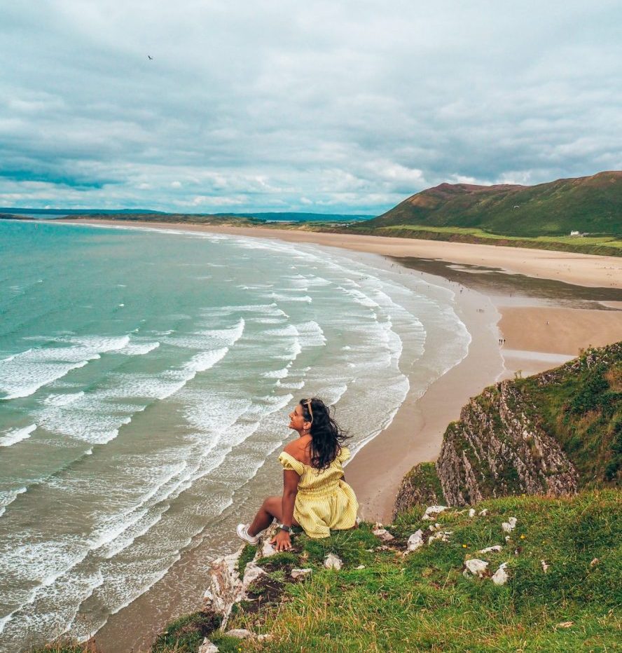 Lucy in yellow dress on cliff overlooking Rhossili Bay, on the Gower Peninsula