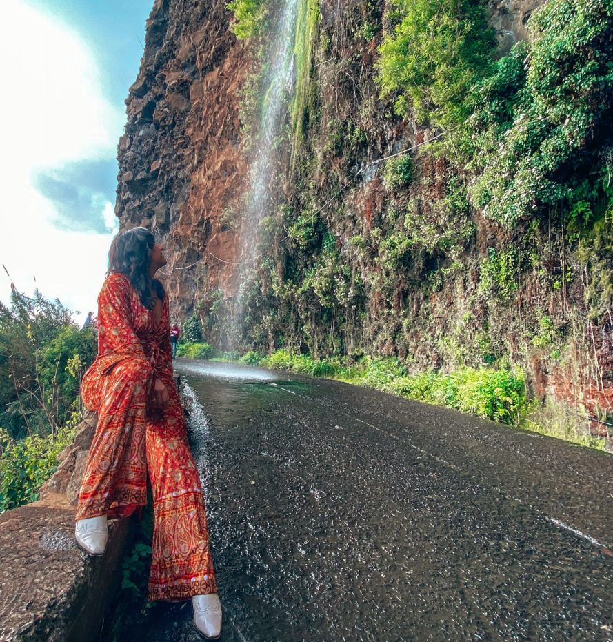 Girl in red jumpsuit from Free People at Cascato dos Anjos " waterfalls of the angel" in Madeira, Portugal